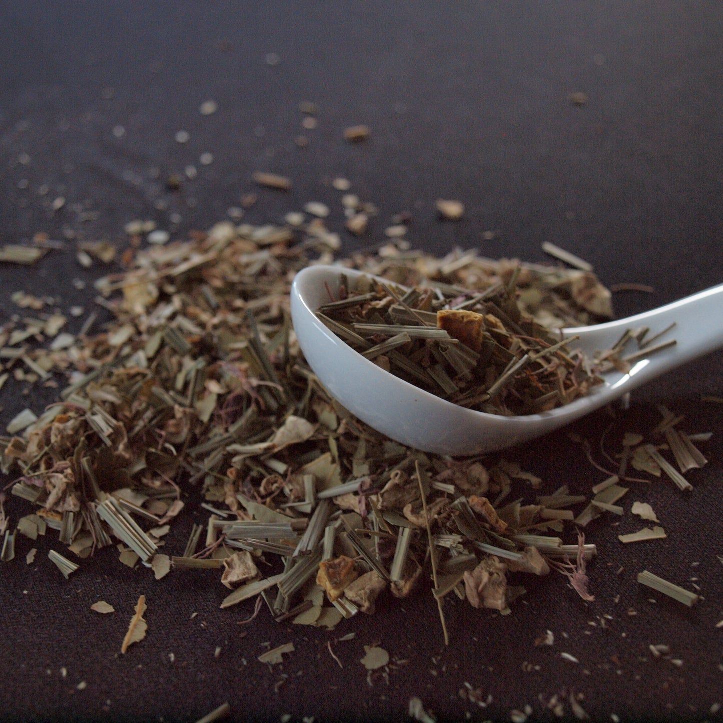 Close-up of a spoon scooping Celestial Chai (Decaf) herbal tea leaves