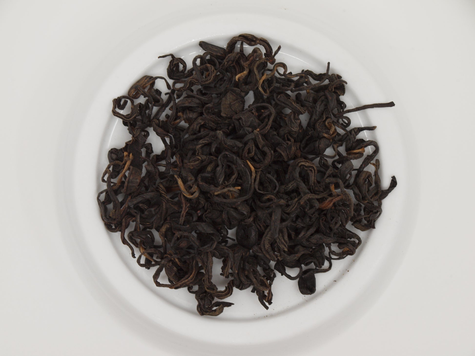 Nepali Oolong tea resting on a porcelain dish, top down perspective